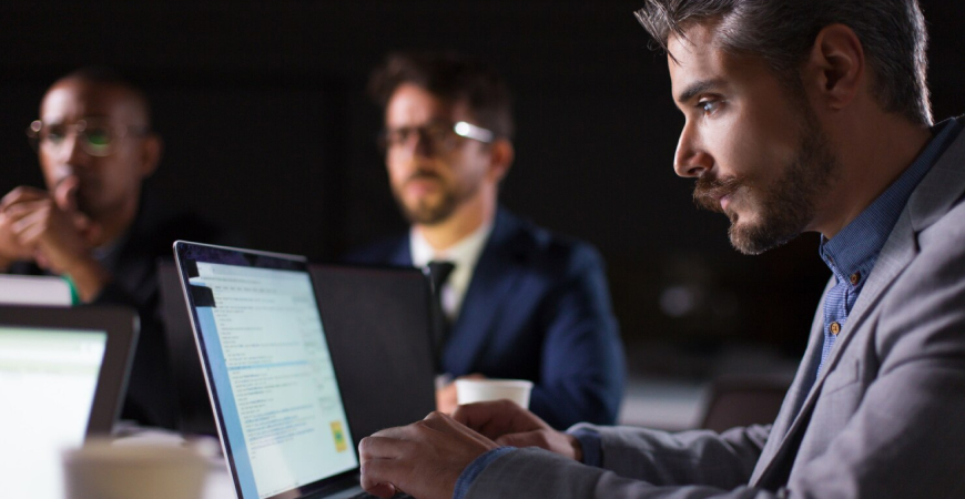 Profissional usando notebook em reunião, ilustrando certificado digital como escolher e usar com segurança no dia a dia da empresa.